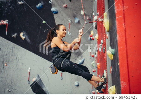 Active happy woman overhanging on tightrope in the training climbing center Active happy woman overhanging on tightrope in the training climbing center 69453425