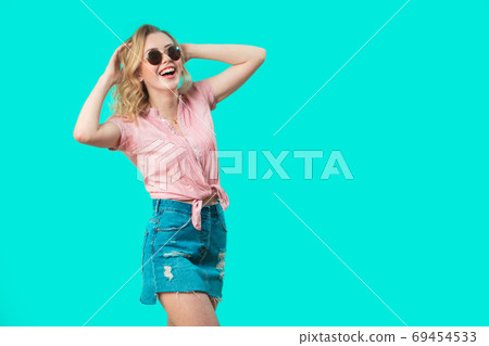 Happy caucasian girl with long curly hair isolated on blue background 69454533