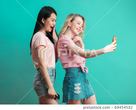 two multiethnic beautiful women asian and caucasian taking selfie at studio two multiethnic beautiful women asian and caucasian taking selfie at studio 69454582