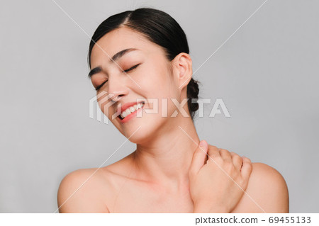 Beautiful asian woman ,young asian girl with clean and bright skin, Cosmetic Beauty Concept,hands touch on the cheek,smily and friendly face isolated on grey background 69455133