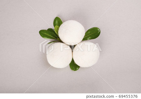 Wool Dryer Balls on a gray background. Eco friendly laundry supplies. Reusable non-toxic wool balls Wool Dryer Balls on a gray background. Eco friendly laundry supplies. Reusable non-toxic wool balls 69455376