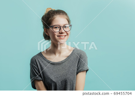 Positive girl with hairbun looking at camera with joyful and charming smile. Positive girl with hairbun looking at camera with joyful and charming smile. 69455704
