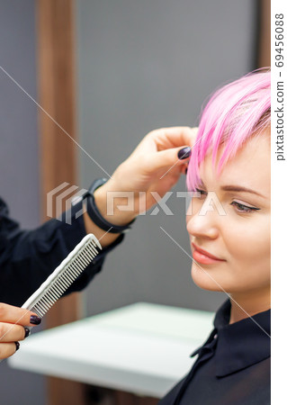 Young woman receiving short pink hairstyle Young woman receiving short pink hairstyle 69456088
