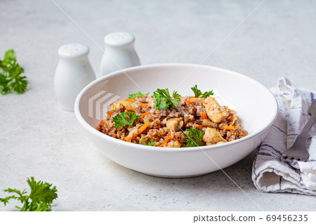 Buckwheat with chicken meat and vegetables in a white plate 69456235