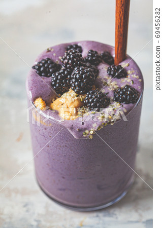 Berry smoothie with peanut butter and hemp seeds in glass. Berry smoothie with peanut butter and hemp seeds in glass. 69456282