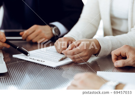 Business people discussing contract working together at meeting in modern office. Unknown businessman and woman with colleagues or lawyers at negotiation Business people discussing contract working together at meeting in modern office. Unknown businessman and woman with colleagues or lawyers at negotiation 69457033