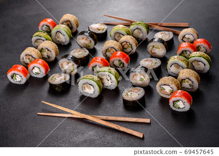 Fresh delicious beautiful sushi rolls on a dark background Fresh delicious beautiful sushi rolls on a dark background 69457645