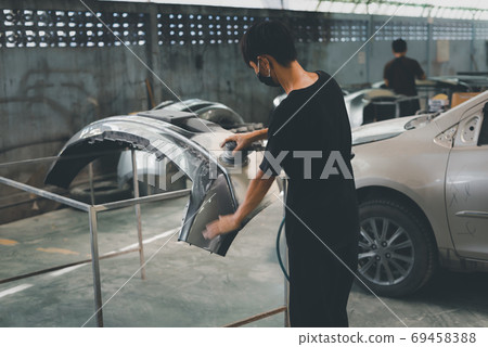 Checking car body work fiber bumper at car garage Checking car body work fiber bumper at car garage 69458388