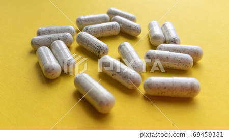 White pill capsules on yellow background. Simple flat lay with pastel texture. Medical concept. Stock photo. White pill capsules on yellow background. Simple flat lay with pastel texture. Medical concept. Stock photo. 69459381