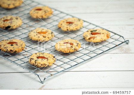 Homemade delicious cookies with almonds on top arrange on stainless griddle Homemade delicious cookies with almonds on top arrange on stainless griddle 69459757