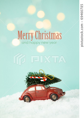 Red toy car with christmas tree aginst blue background with christmas lights Red toy car with christmas tree aginst blue background with christmas lights 69460785