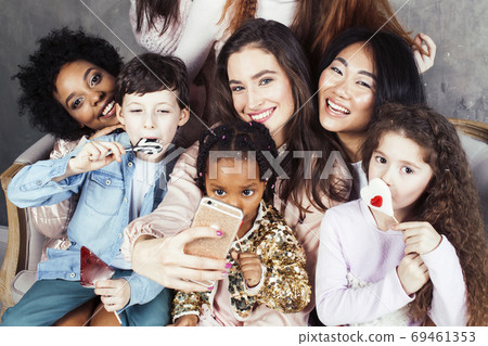 Lifestyle and people concept: young pretty diversity nations woman with different age children celebrating on birth day party together happy smiling, making selfie. African-american, asian and Lifestyle and people concept: young pretty diversity nations woman with different age children celebrating on birth day party together happy smiling, making selfie. African-american, asian and 69461353