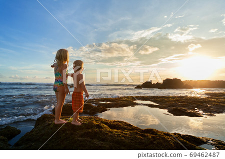 Happy kids walk with fun by sunset sea beach Happy kids walk with fun by sunset sea beach 69462487