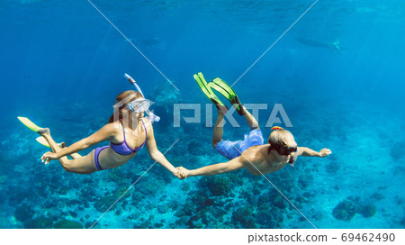 Young couple in snorkeling mask free dive underwater in sea 69462490