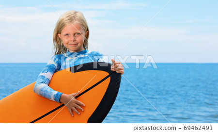 Young surfer learn to ride on surfboard on sea waves 69462491