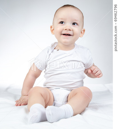 Photo of a ten-month-old smiling baby looking left and up 69462796
