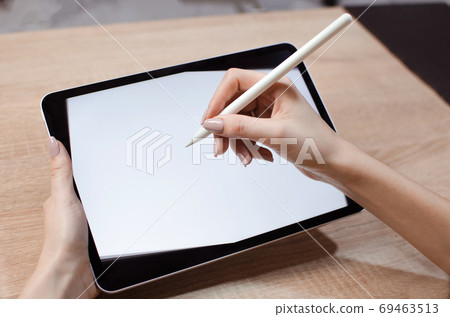 Girl using stylus on tablet to draw 69463513