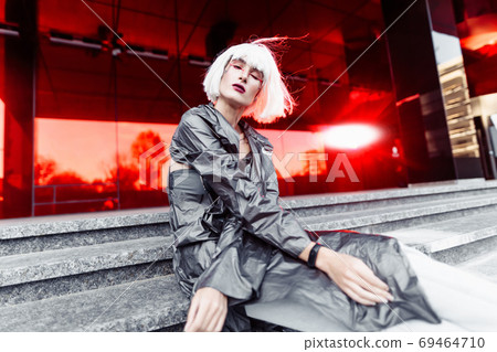 Futuristic fashion. Blonde on a red futuristic background. Futuristic fashion. Blonde on a red futuristic background. 69464710