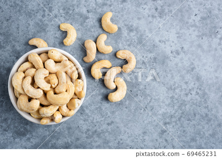 Cashews in bowl on concrete background 69465231