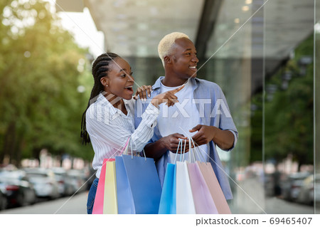 Surprised african american guy and girl saw original thing in shop window 69465407