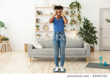 Woman Stressing Out About Gaining Weight Standing On Scales Indoor Woman Stressing Out About Gaining Weight Standing On Scales Indoor 69465582