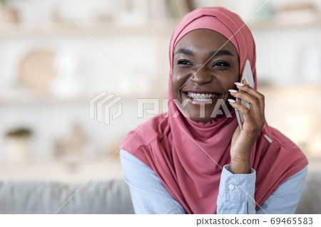 Phone Call. Black Muslim Girl In Hijab Talking On Cellphone At Home Phone Call. Black Muslim Girl In Hijab Talking On Cellphone At Home 69465583