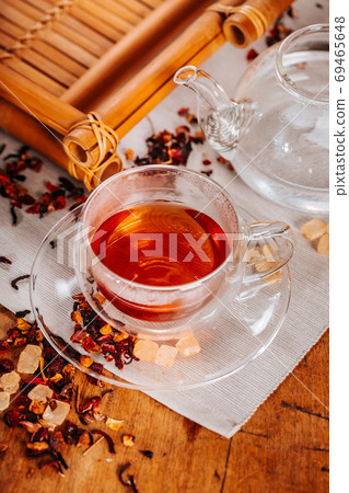 Cup of hot tea with rock sugar, dry tea leaves served in thermo glass tea cup Cup of hot tea with rock sugar, dry tea leaves served in thermo glass tea cup 69465648