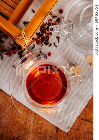 Cup of hot tea with rock sugar, dry tea leaves served in thermo glass tea cup Cup of hot tea with rock sugar, dry tea leaves served in thermo glass tea cup 69465651