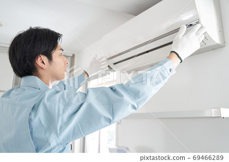 Japanese male electrician installing a home air conditioner Japanese male electrician installing a home air conditioner 69466289