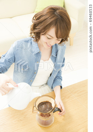 A woman who is making coffee 69468533