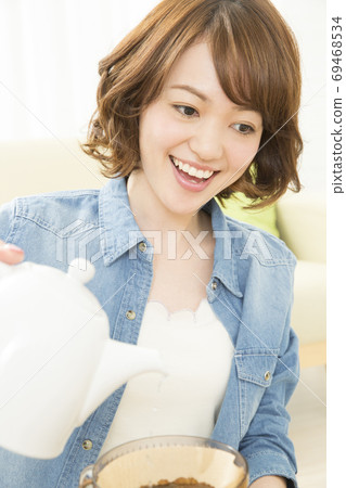 A woman who is making coffee A woman who is making coffee 69468534