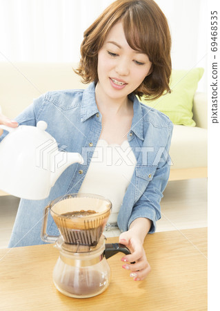 A woman who is making coffee A woman who is making coffee 69468535