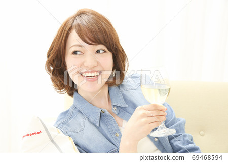 A woman drinking white wine 69468594