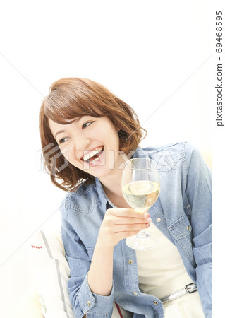 A woman drinking white wine A woman drinking white wine 69468595