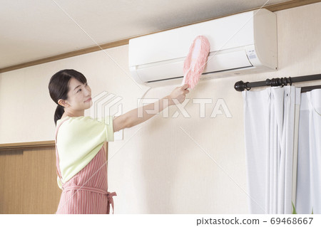 一個女人用方便的拖把擦空調 一個女人用方便的拖把擦空調 69468667