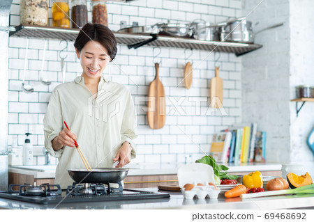 Middle woman cooking in the kitchen Middle woman cooking in the kitchen 69468692