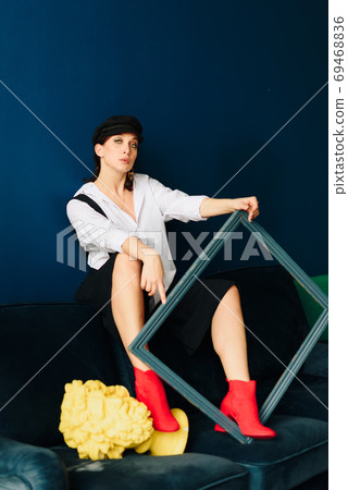 Portrait of a beautiful young woman in a white shirt and black pants in the Studio 69468836