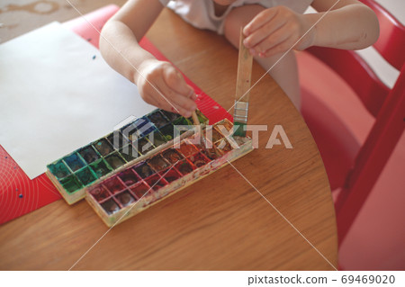 Three year old boy paint with watercolor at home.  69469020