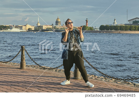 Happy man dances in city center. 69469485