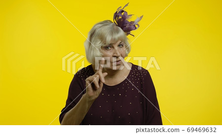 Senior old woman showing admonishing finger gesture, disapproval sign, asking to stop. Slow motion 69469632