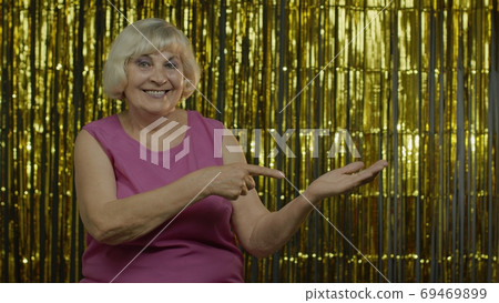 Senior old woman pointing empty place on her palm, copy space advertising area on hand 69469899