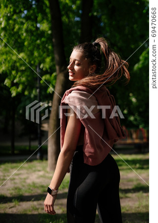 Young woman is resting after jogging in the park. 69470668