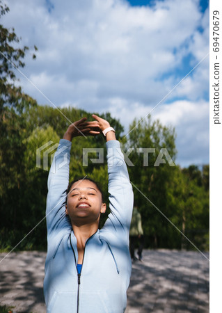 Girl in sports uniform warming up before jogging Girl in sports uniform warming up before jogging 69470679