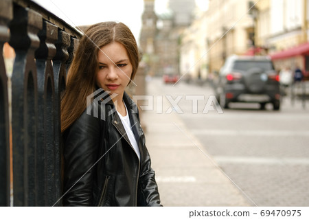 Young woman sitting at the street of a big city. Young woman sitting at the street of a big city. 69470975
