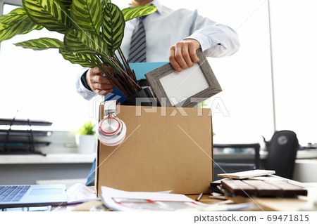 Man business clothes puts things into box at office Man business clothes puts things into box at office 69471815