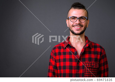 Face of happy bearded Turkish hipster man with eyeglasses smiling Face of happy bearded Turkish hipster man with eyeglasses smiling 69471816
