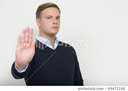 Portrait of man with blond hair showing stop gesture Portrait of man with blond hair showing stop gesture 69472188
