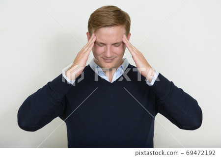 Portrait of stressed man with blond hair having headache 69472192