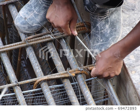 KUALA LUMPUR, MALAYSIA -OCTOBER 16, 2017: Construction workers fabricating steel reinforcement bar at the construction site. The reinforcement bar was tied together using tiny wires 69472893