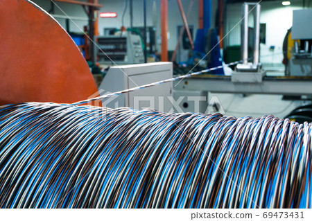 A coil of power electric cable in insulation on a metal coil A coil of power electric cable in insulation on a metal coil 69473431